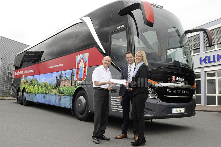 Busunternehmer Werne Henke (links) bekommt von den Aftersales-Mitarbeitern Martina Schmitt und Hans-Jürgen Bühler den 1000 Omniplus Service-Vertrag Premium überreicht.